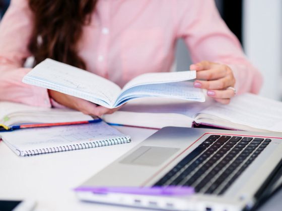 mujer estudiando en su libreta y ordenador